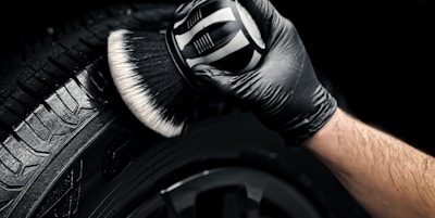 a man with a glove on his hand is polishing the tire of a car